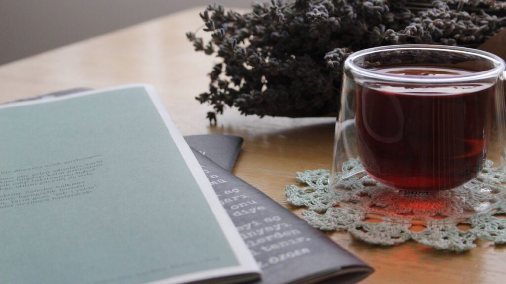 Tasse d'infusion, lavande et carnet ouvert sur une table en bois